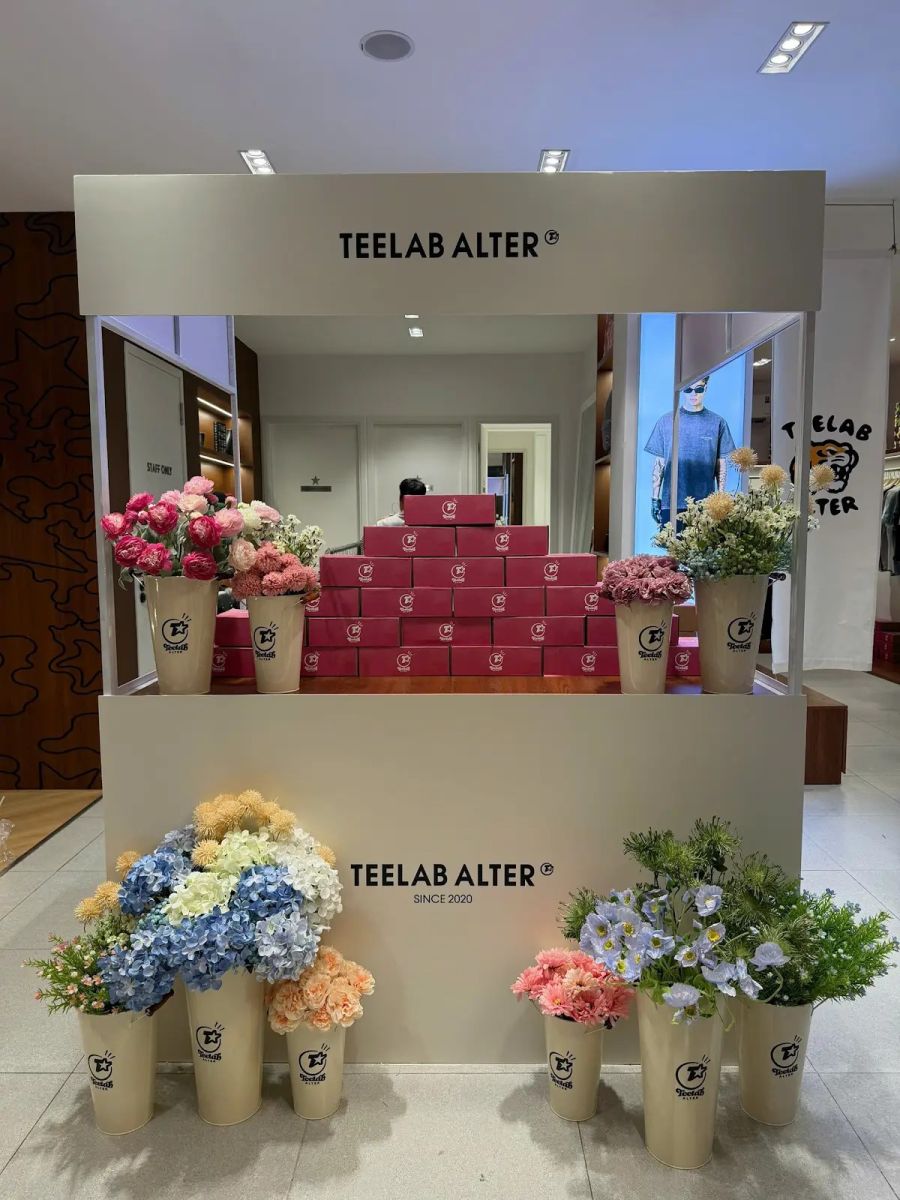 Photobooth TEELAB ALTER với quầy trưng bày hoa và hộp quà